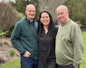 Maria Van Pelt stands between her husband, Rick, and Dennis, a driver whose life she saved with CPR.